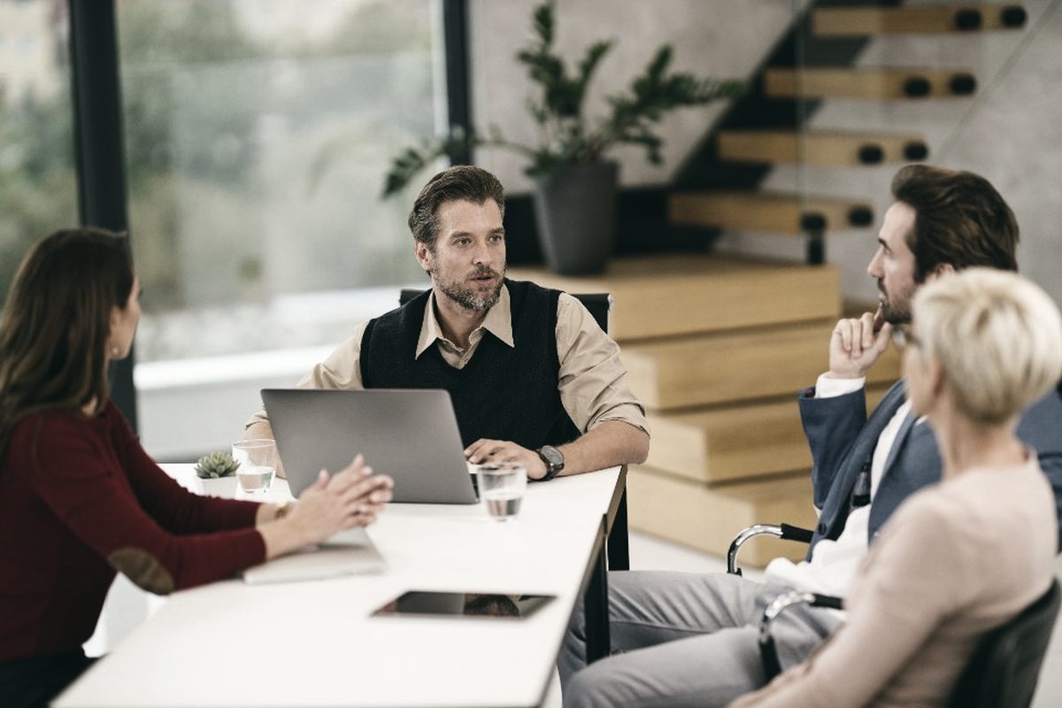 Sessão de trabalho em sala de reunião, com a liderança acompanhando a apresentação